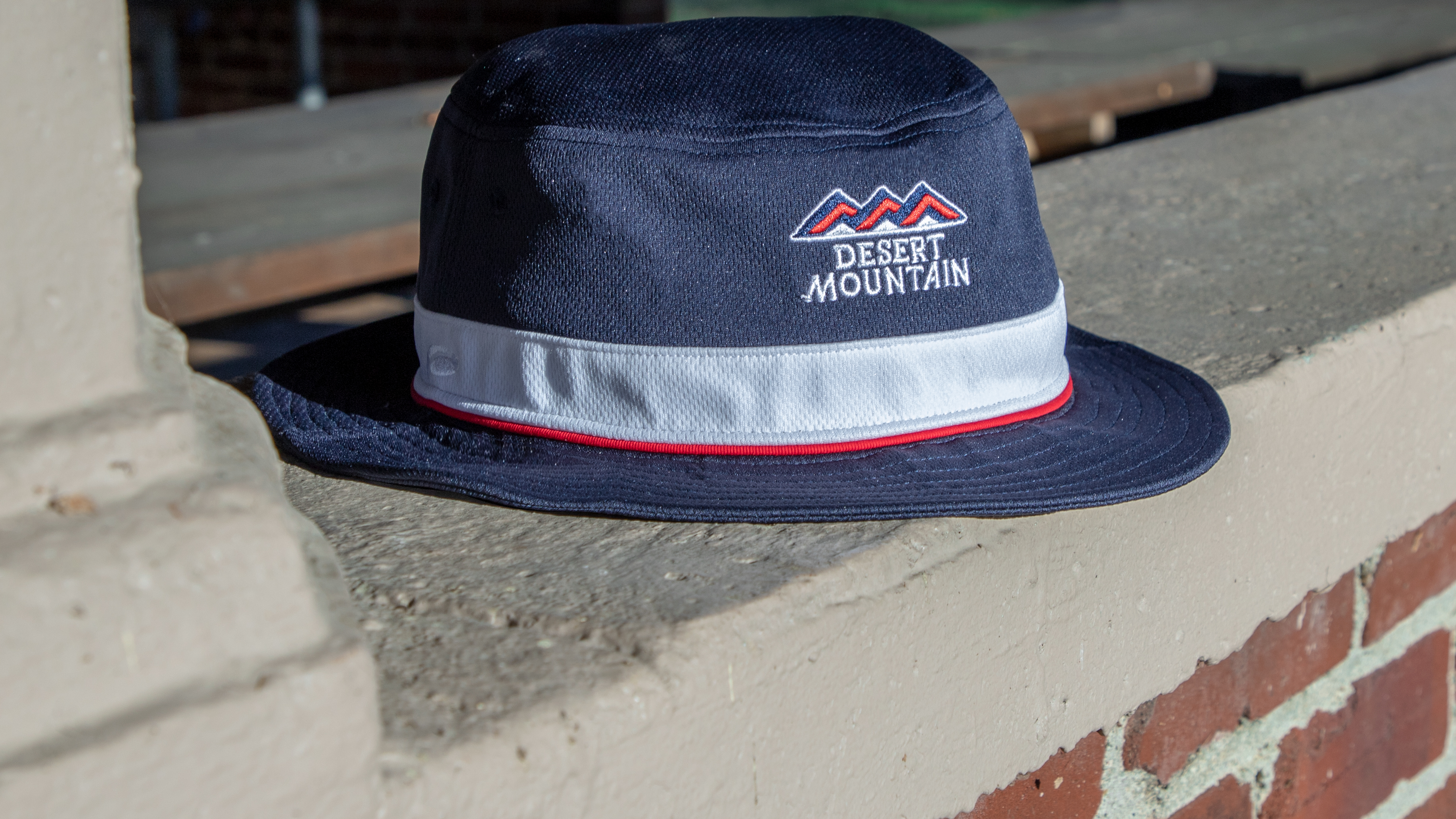 Small Brim Bucket Hat sitting on brick wall