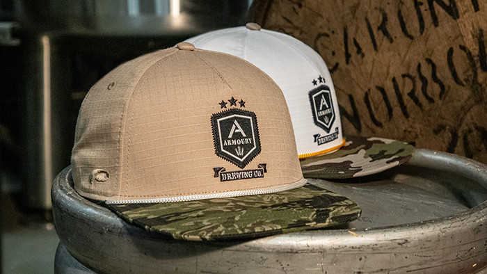 A pair of brewery hats sitting on a keg