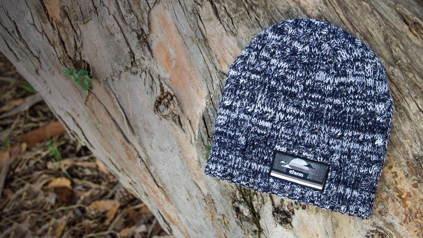 Cable Knit laying on a wood log