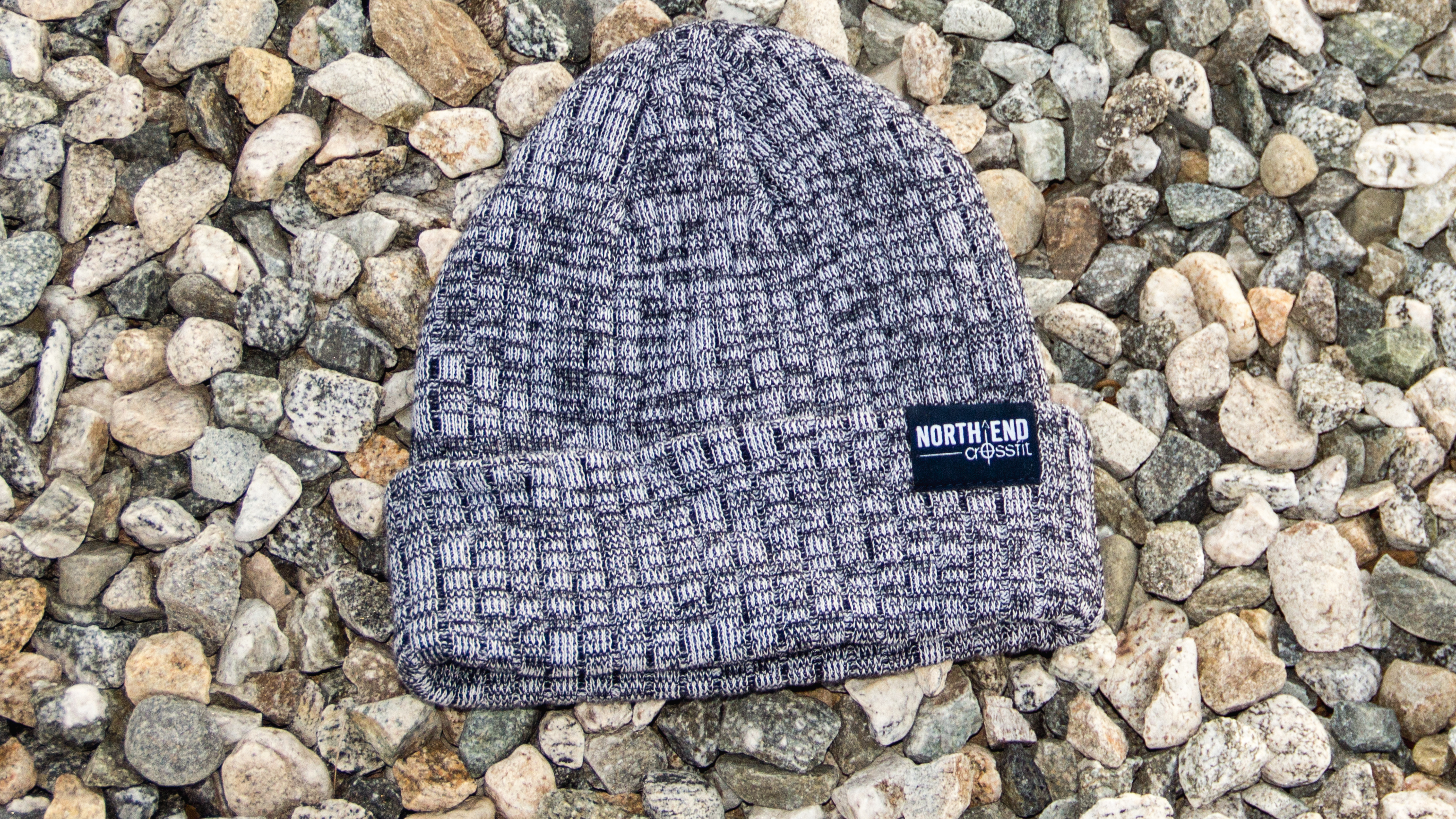 Belafonte Knit laying on a bed of small stones